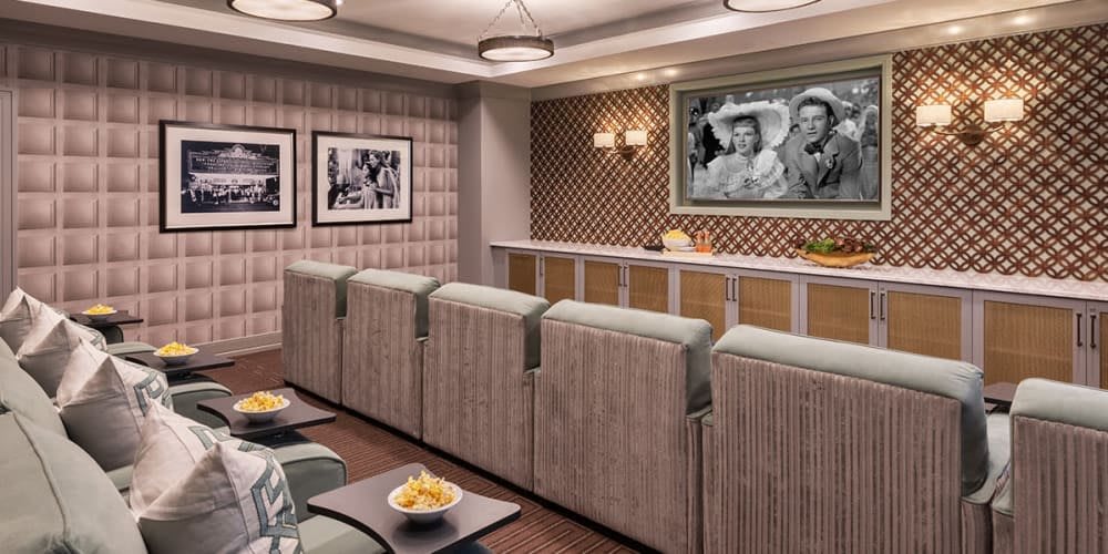 A stylish home theater with comfortable seating and classic movie artwork on the walls.