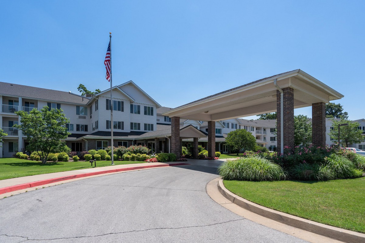 Entrance of a large building with a driveway and American flag.