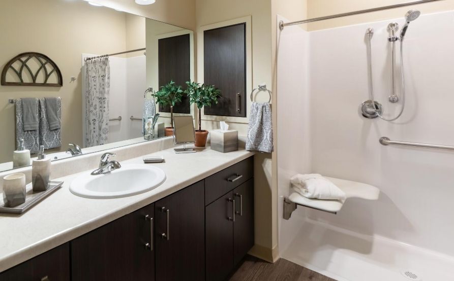 A modern, well-organized bathroom with a sink, countertop, and shower.