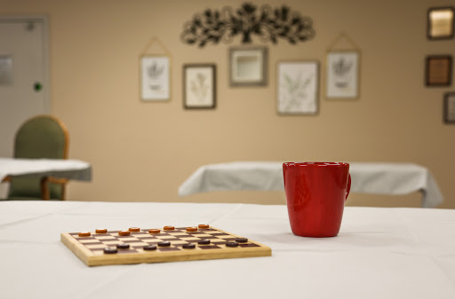A cozy setting featuring a checkers board game and a red cup, perfect for a casual game night.