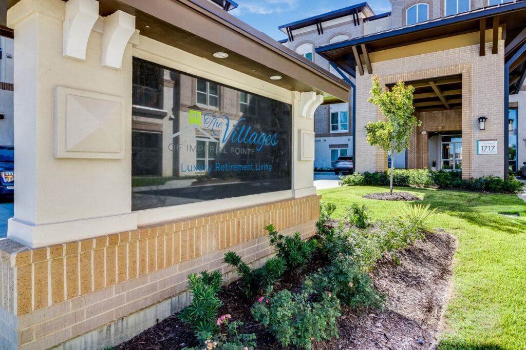 Entrance of an apartment complex with signage and landscaping.