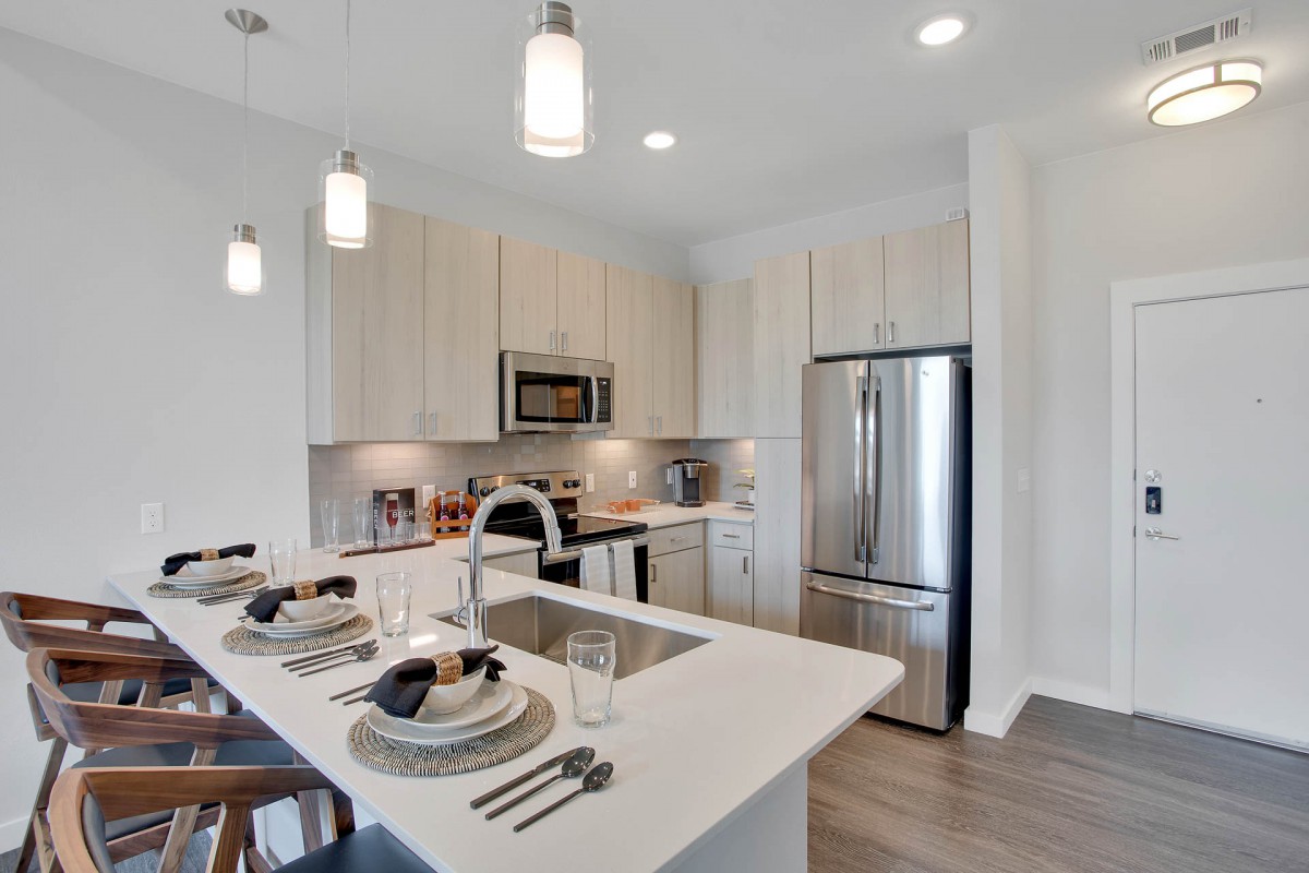 A modern kitchen with a sleek design, featuring stainless steel appliances and a stylish dining area.
