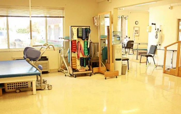 A physical therapy room with various rehabilitation equipment and exercise areas.