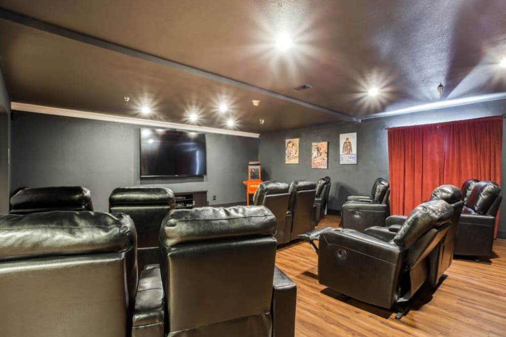 A cozy home theater with leather recliners and a large screen.
