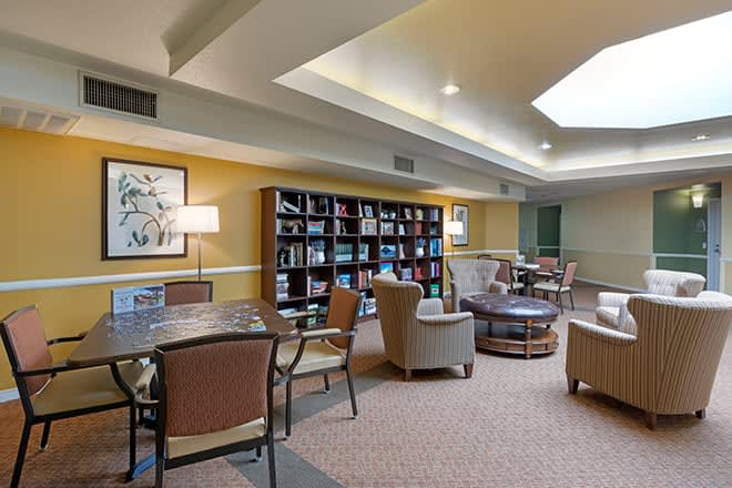 A cozy lounge area featuring bookshelves and comfortable seating.