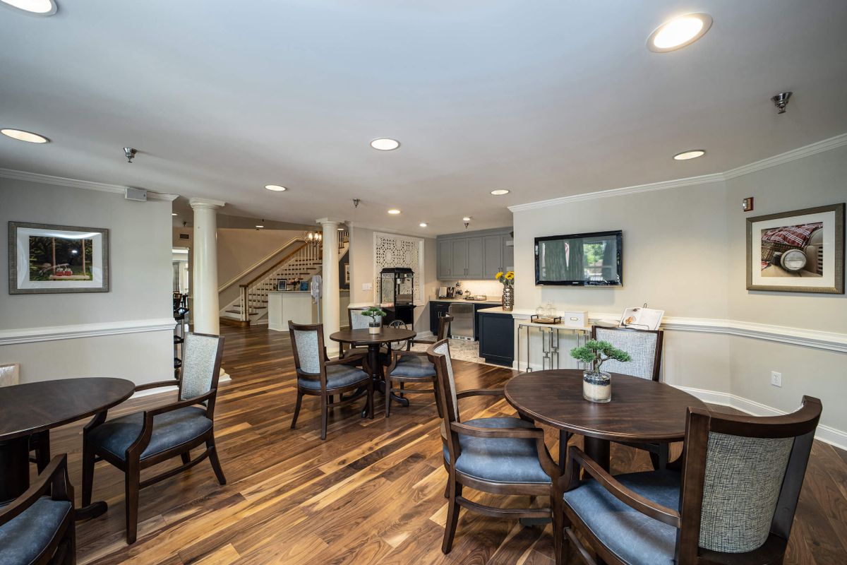 A spacious and modern dining area with wood flooring and elegant furniture.