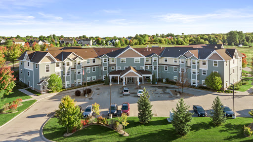 A picturesque hotel surrounded by lush greenery and a spacious parking area.