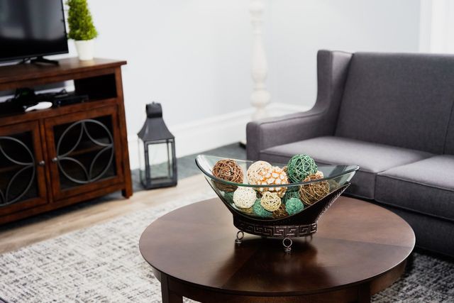 A modern living room with a decorative bowl on a wooden coffee table.