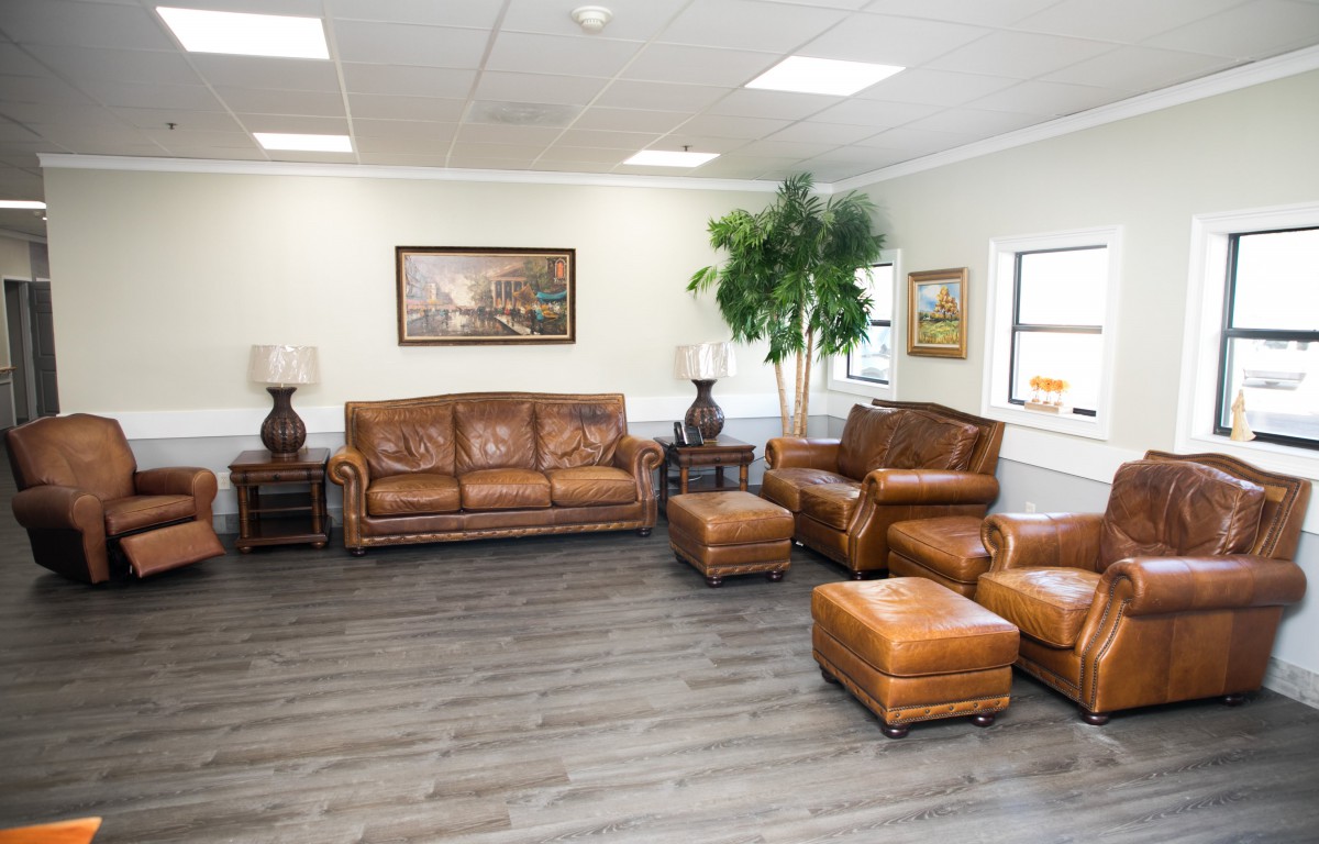 A spacious living room with leather furniture and hardwood flooring.