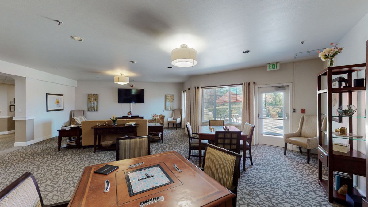 A cozy lounge and dining area with tables and a chess board.
