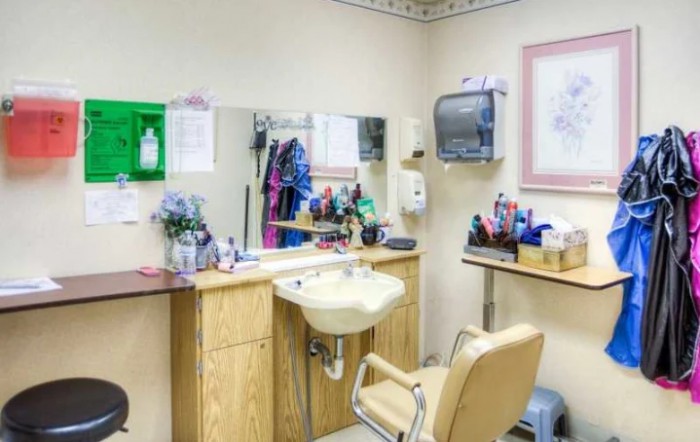 A well-equipped hair salon with a sink, mirror, and styling chair.