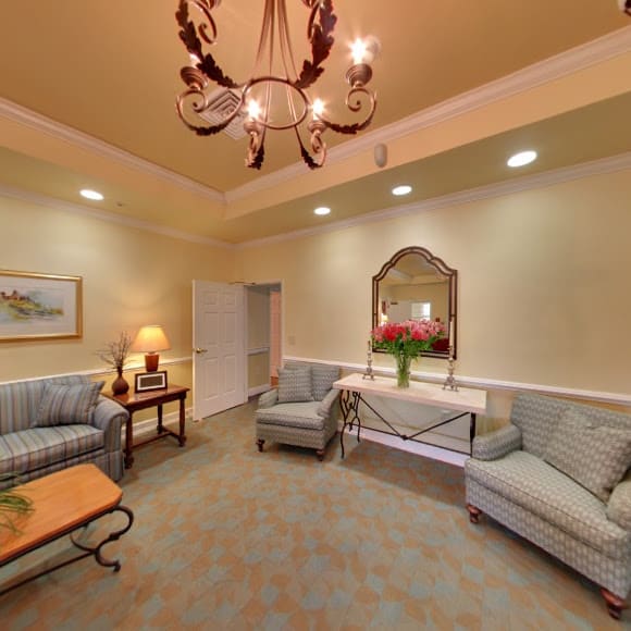 A cozy living room with elegant furniture and a chandelier.