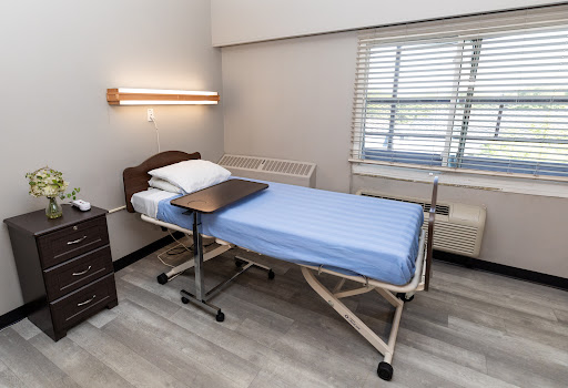 A clean and well-lit hospital room featuring an adjustable patient bed.