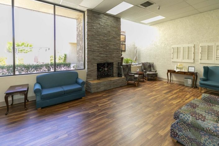 A cozy living room with a fireplace, sofas, and wood flooring.