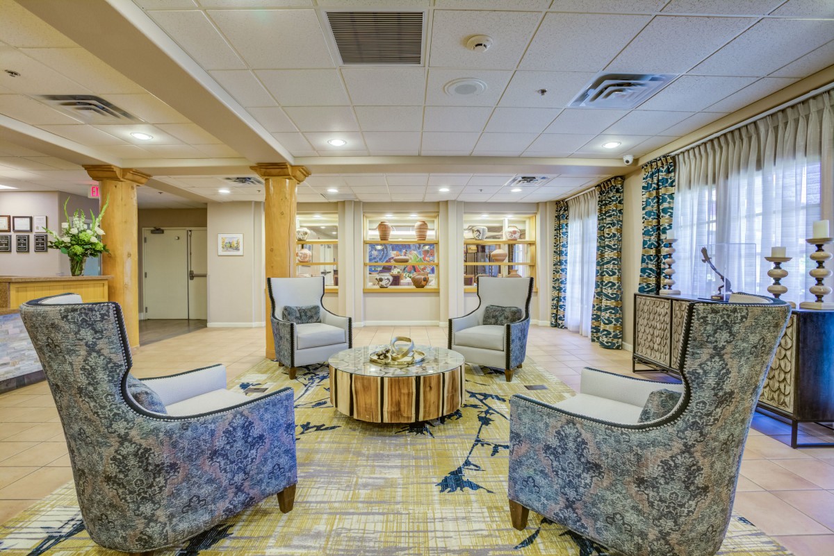 A modern and cozy lobby seating area with comfortable chairs and wooden accents.