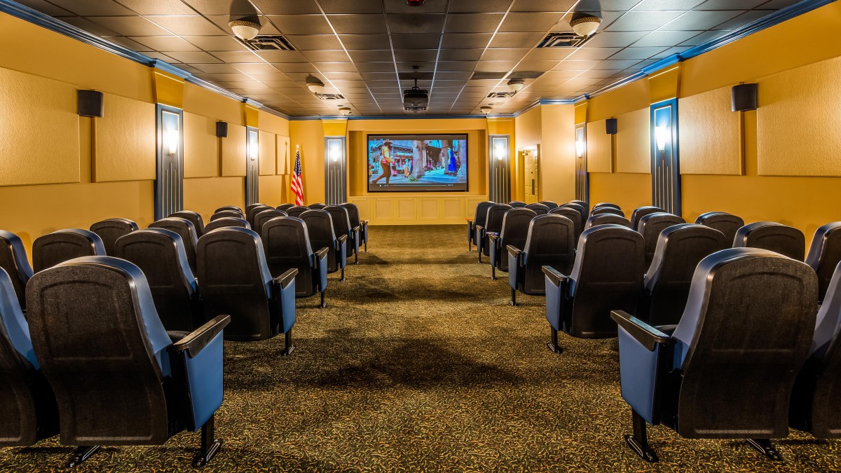 A modern theater with rows of comfortable seating facing a large screen.