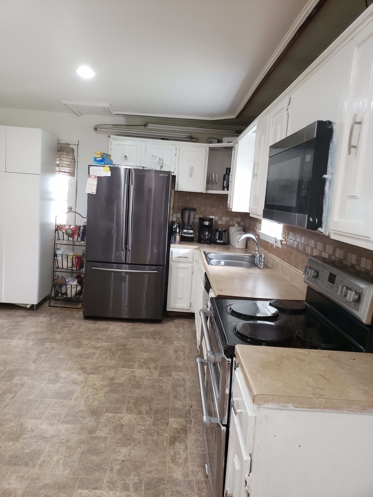 A modern kitchen with stainless steel appliances and white cabinets.