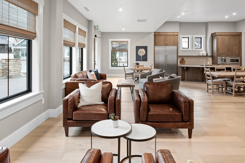 A modern living room featuring leather chairs and an open layout with neutral tones.