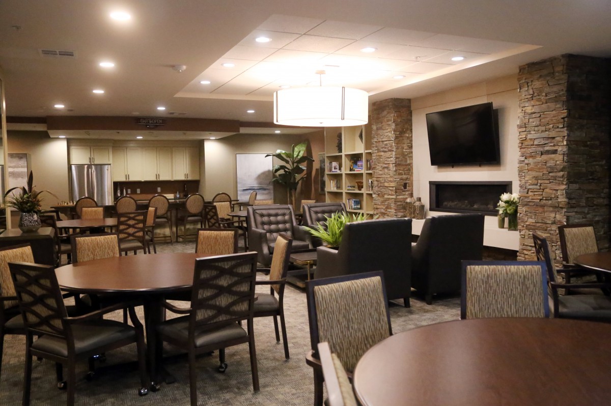A modern lounge area with comfortable seating, a television, and warm lighting.