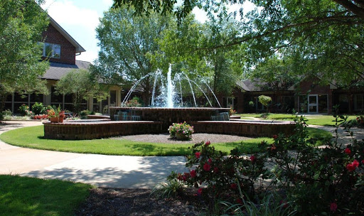 A serene garden featuring a beautiful fountain, surrounded by lush greenery and vibrant flowers.
