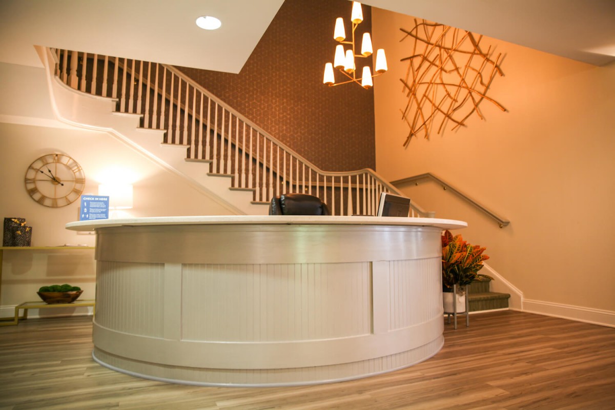 A modern reception area with a staircase and elegant lighting.