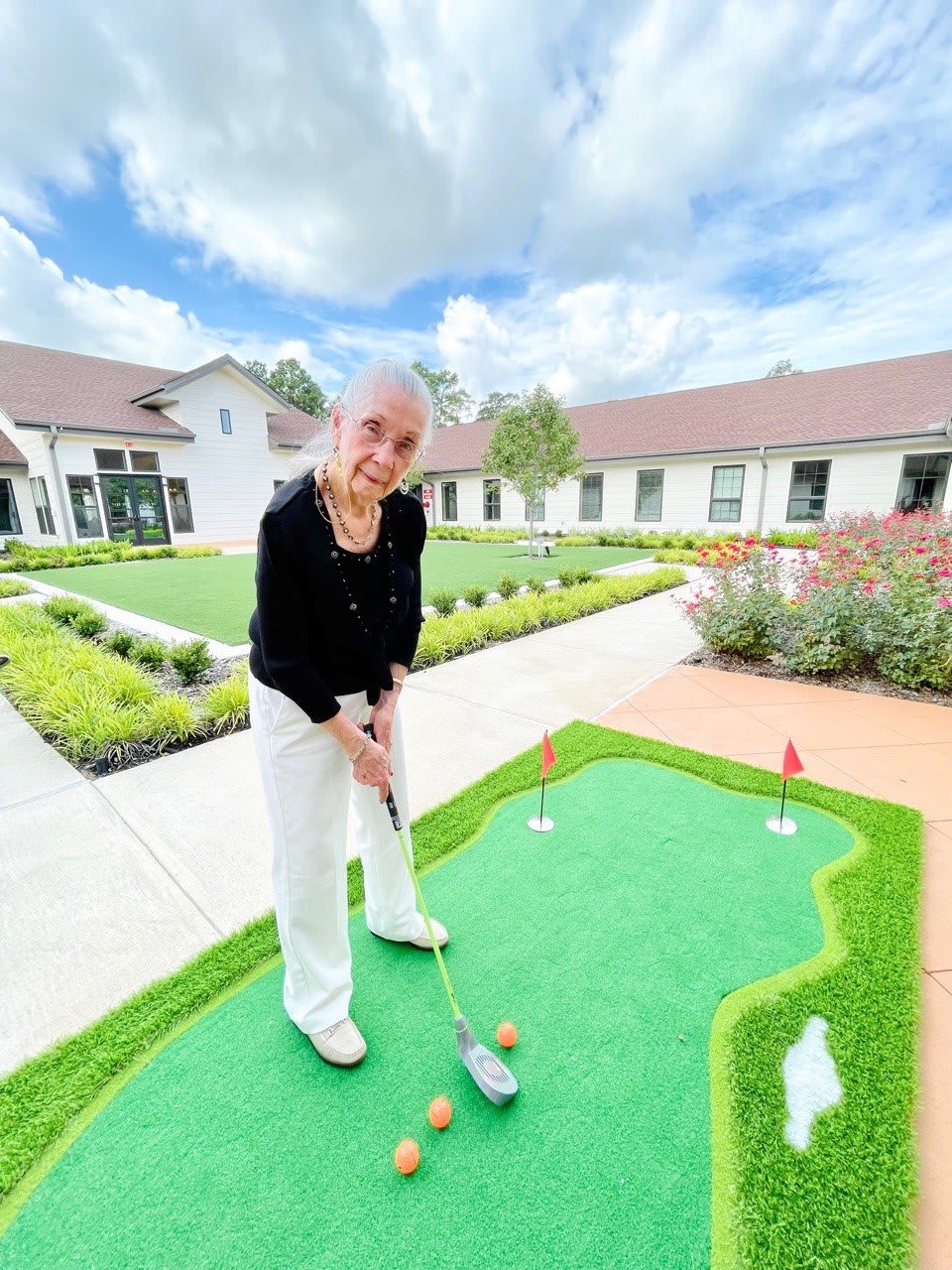 A person enjoying a game of mini golf on a bright, sunny day.