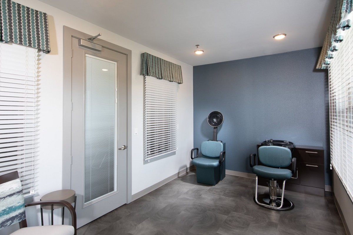 A cozy salon waiting area with chairs and a hair dryer.