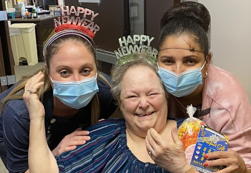 A joyful New Year celebration with caregivers and a happy resident.