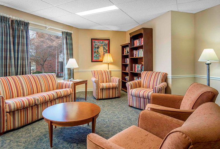 A cozy living room with comfortable armchairs and a bookshelf.