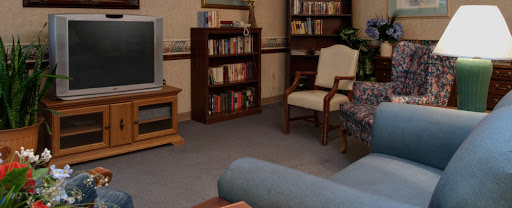 A cozy living room featuring a bookshelf, television, and comfortable seating.