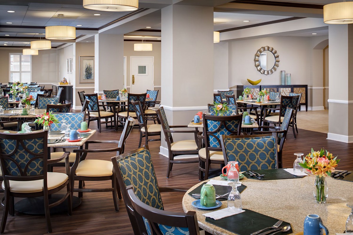 A cozy dining area with neatly arranged tables and chairs, featuring elegant decor.