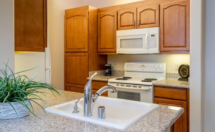 Modern kitchen with wooden cabinets and white appliances.
