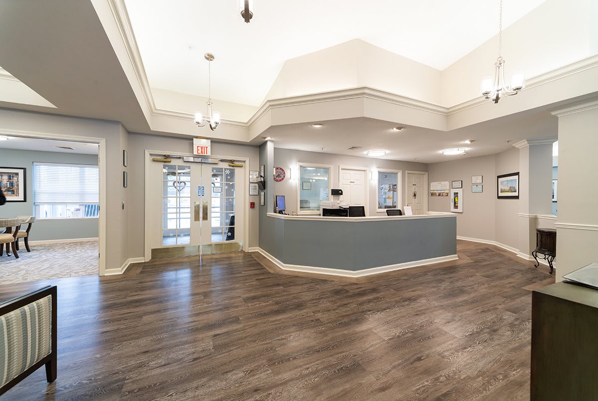 A modern reception area with a central desk and wooden flooring.