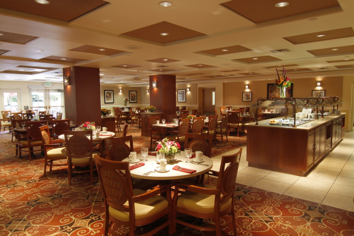 Cozy restaurant dining area with elegantly set tables and warm lighting.