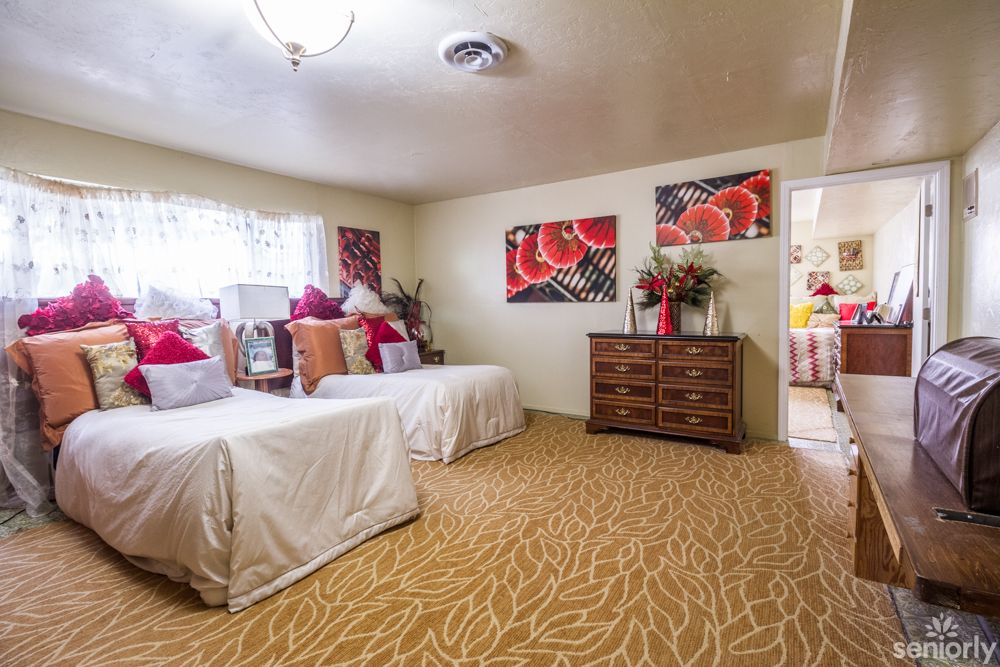 A cozy bedroom with twin beds, vibrant decor, and elegant furnishings.