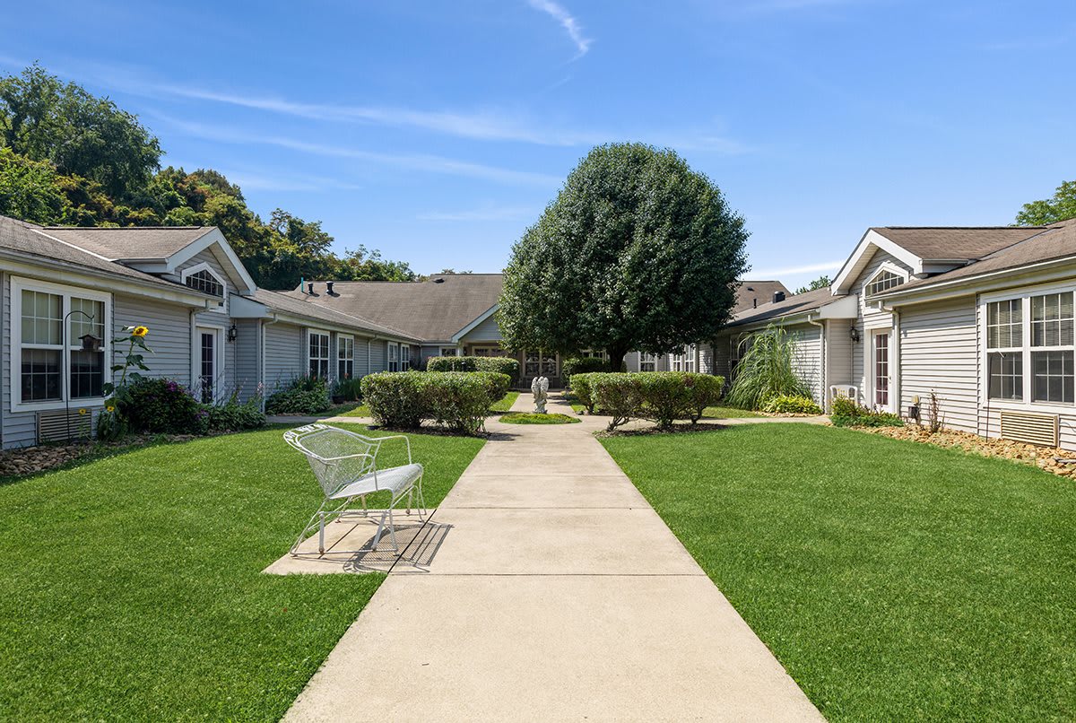 A peaceful suburban neighborhood with a central pathway and lush greenery.