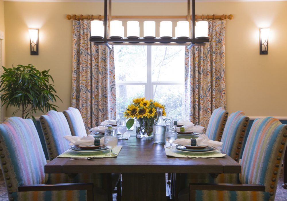 A beautifully arranged dining room table with sunflowers as a centerpiece.
