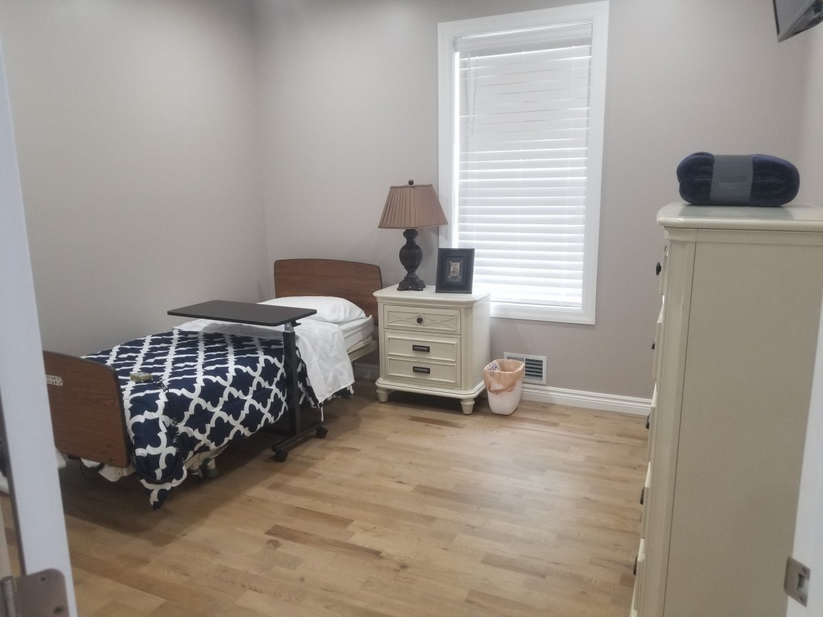 A cozy bedroom with a single bed, nightstand, and dresser.