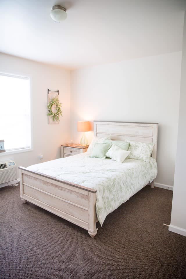 A cozy bedroom with a neatly made bed, soft lighting, and simple decor.