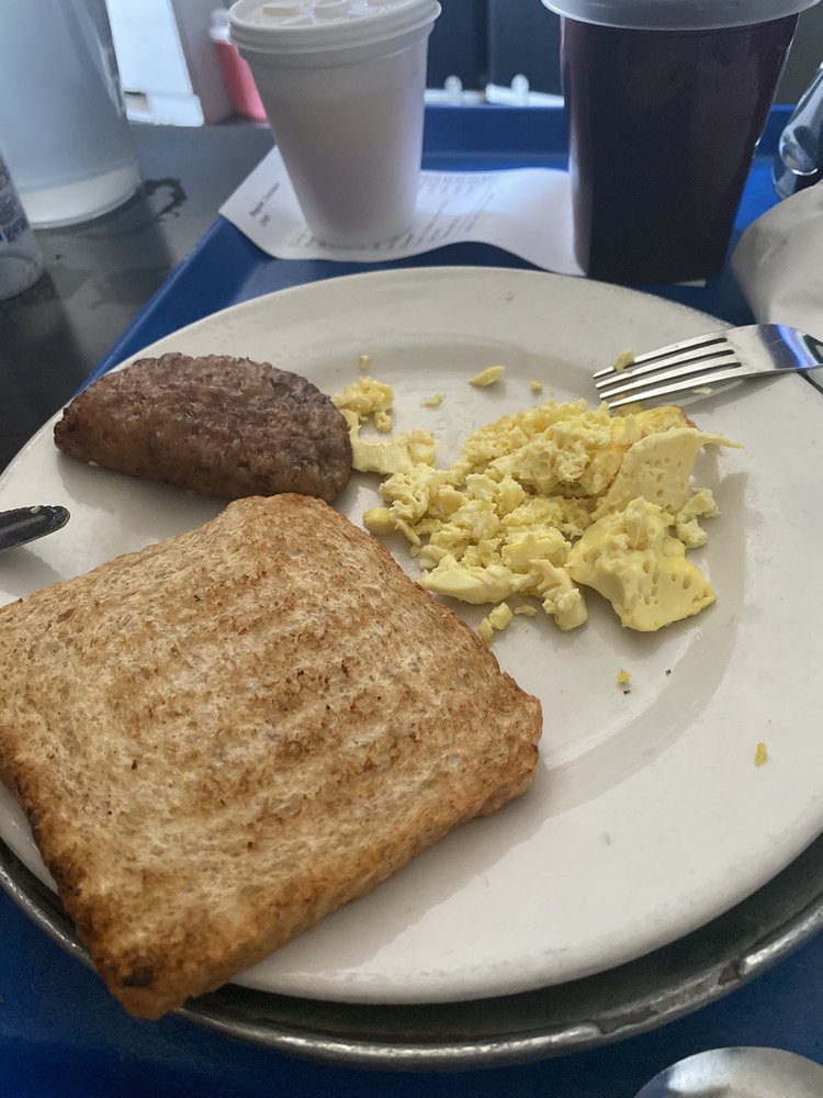 A breakfast plate featuring toast, scrambled eggs, and sausage.
