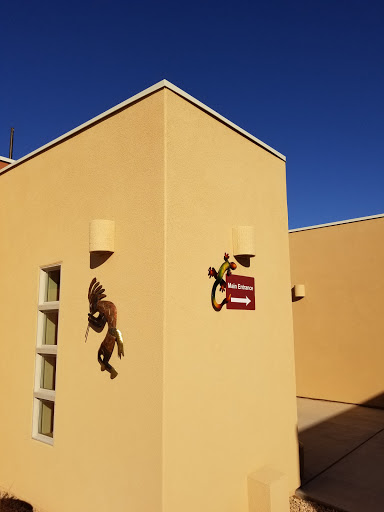 A close-up view of a yellow exterior wall featuring a lizard sculpture and a directional sign.