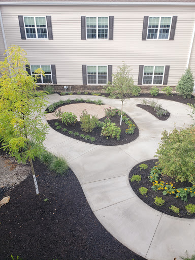 A well-designed garden pathway surrounded by lush greenery and flowerbeds.