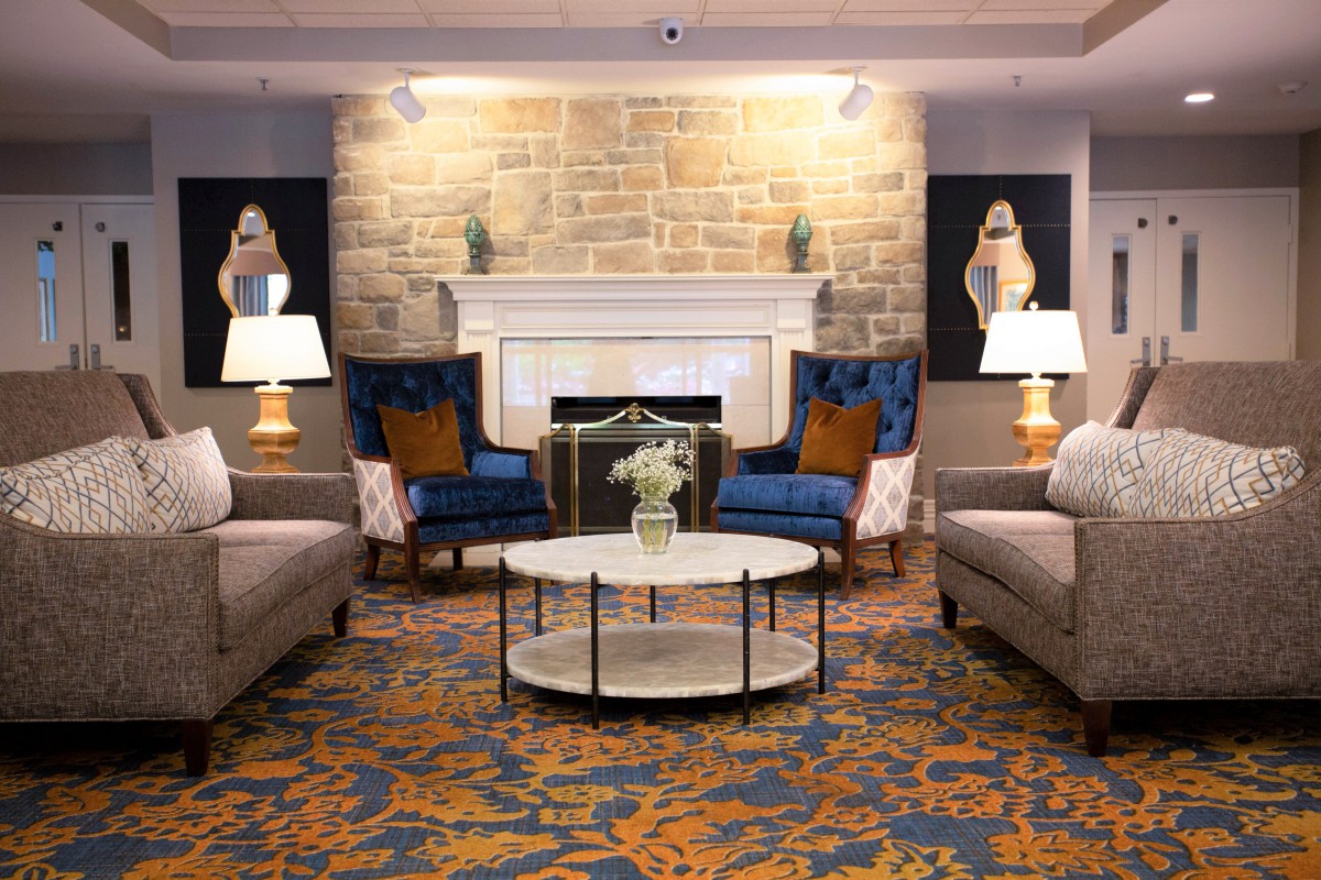 A cozy living room with elegant furniture, featuring a fireplace and decorative furnishings.