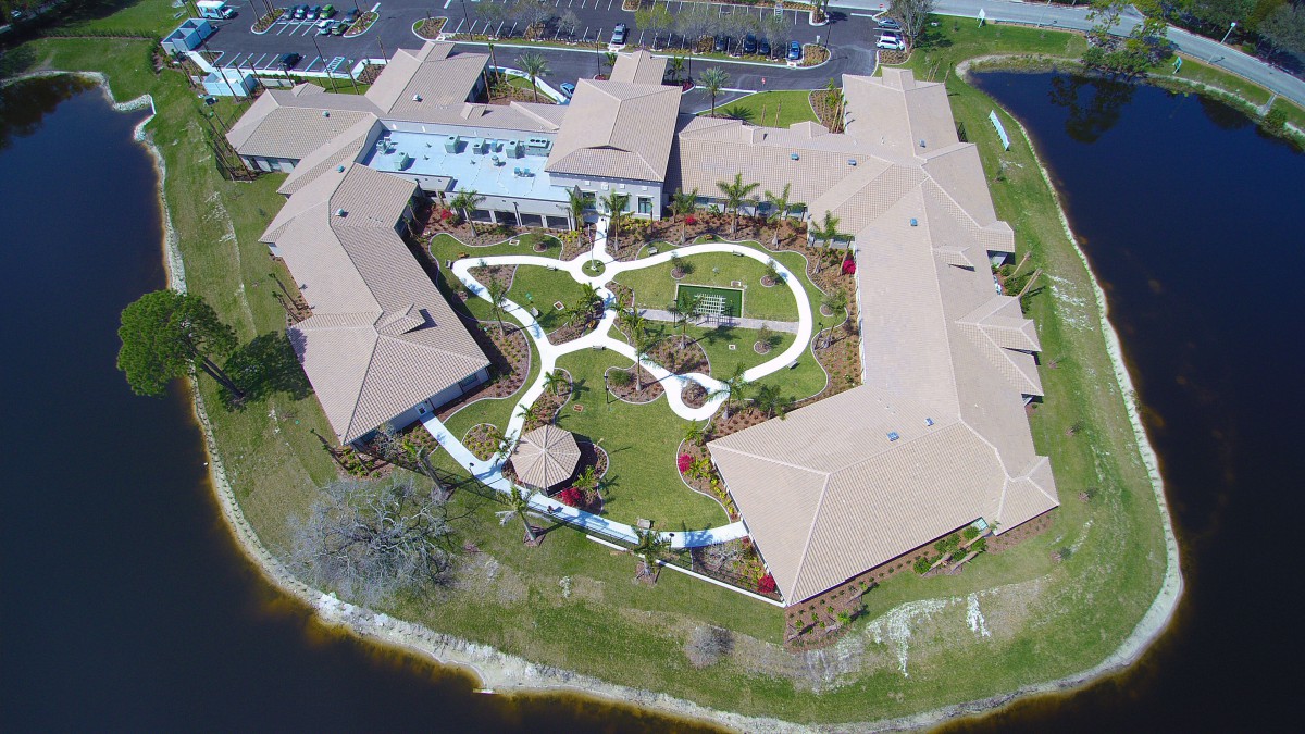 An aerial view of a large building complex with landscaped gardens and winding walkways.