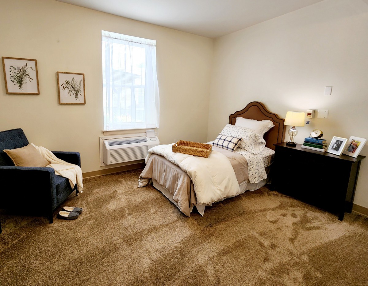 A cozy bedroom with a single bed, warm lighting, and elegant decor.