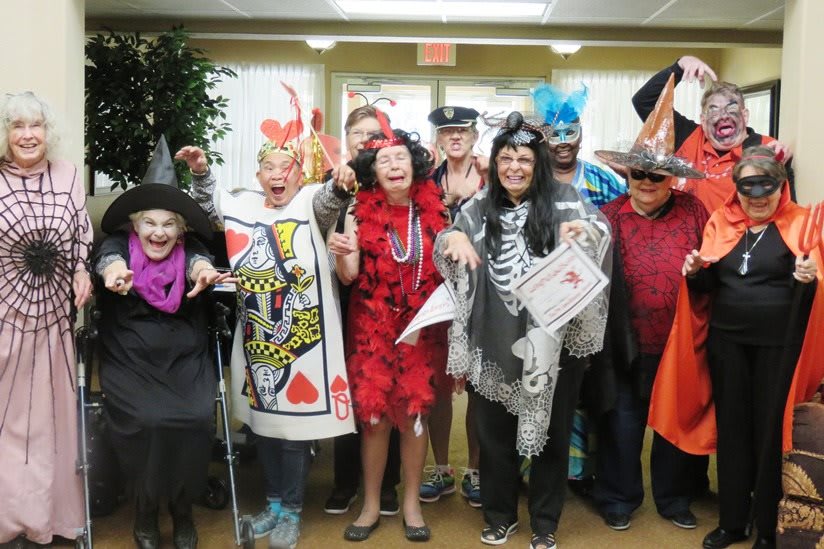 A group of people dressed in various costumes for a festive Halloween celebration.