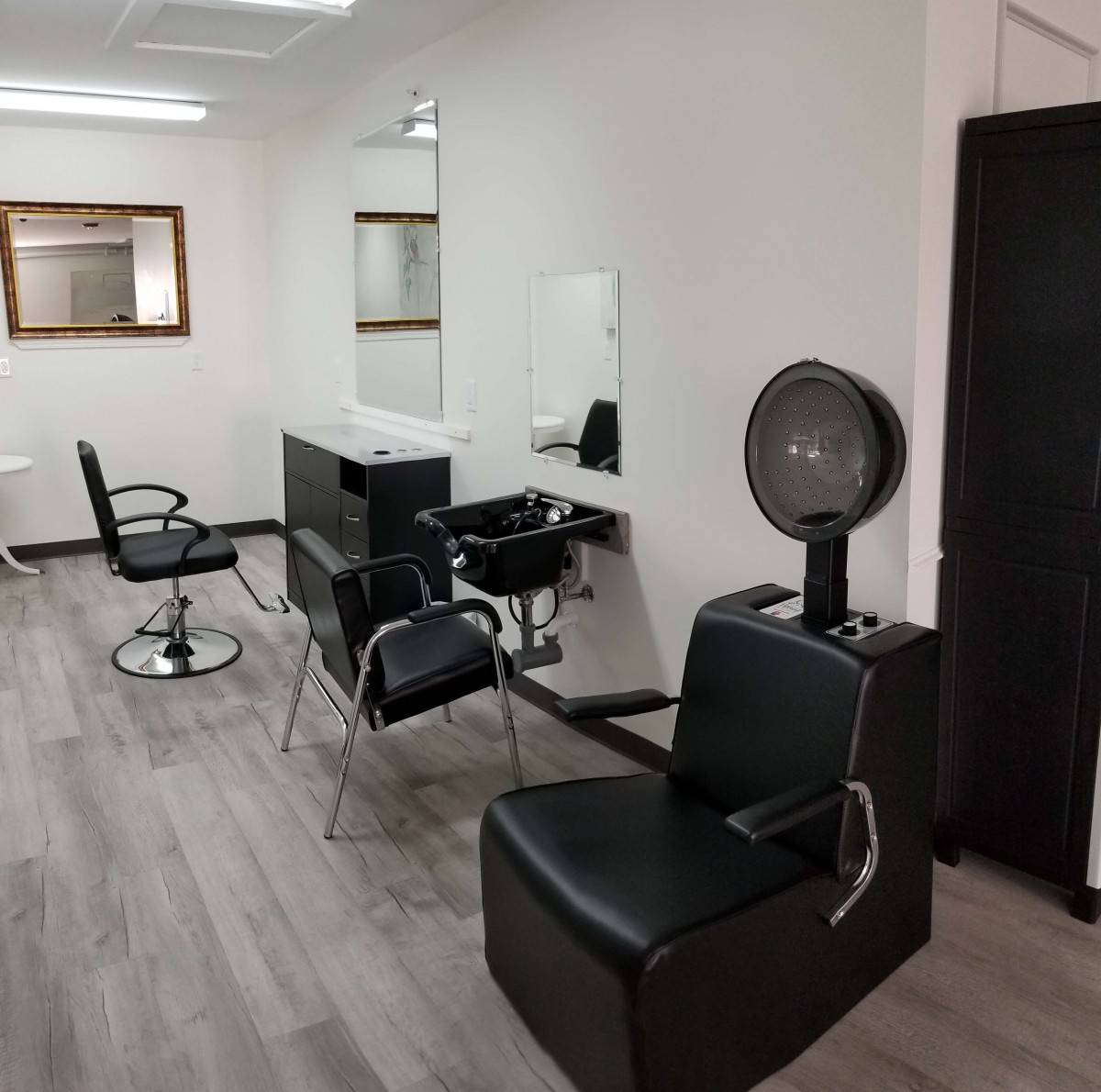 A modern hair salon interior with styling stations and chairs.