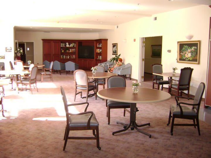 A spacious room with several tables and chairs, suitable for dining or meetings.