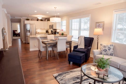 A modern open-plan living room and kitchen with stylish furniture and bright lighting.