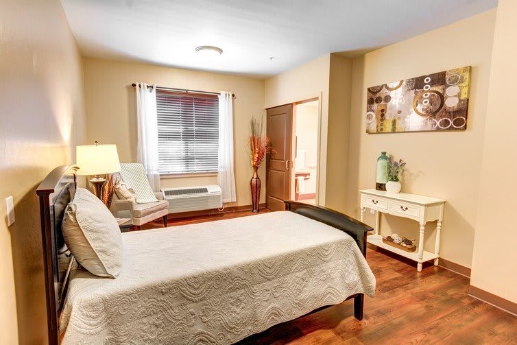 A cozy and minimalist bedroom featuring a single bed, wooden flooring, and soft lighting.
